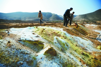 工人在甘肃省白银市把掺杂了化学试剂的受污染土壤埋入淋洗池中